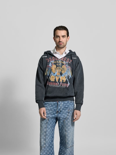 Männermodel trägt Oversized Hoodie aus Baumwolle von Dsquared2 in Schwarz mit Used-Look, Kapuze mit Tunnelzug, Känguru-Tasche, Ganzkörperansicht von vorne.