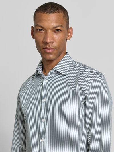 Männermodel trägt Slim Fit Business-Hemd mit Kentkragen von Jake*s aus Reine Baumwolle mit Knopfleiste, Sportmanschetten, Nahaufnahme Oberkörper.