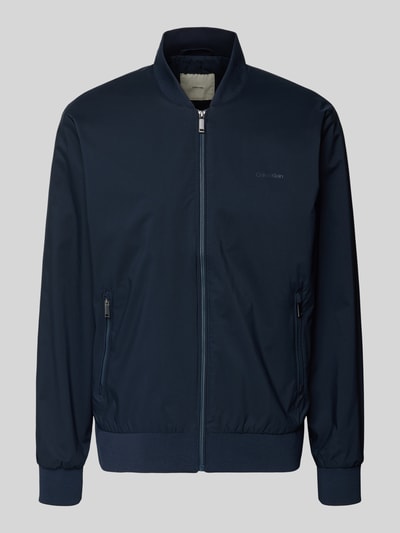 Produktfoto, dunkelblaue Bomberjacke mit Reißverschlusstaschen Modell 'MATTE' von CK Calvin Klein, gerader Schnitt, kurzer Stehkragen.