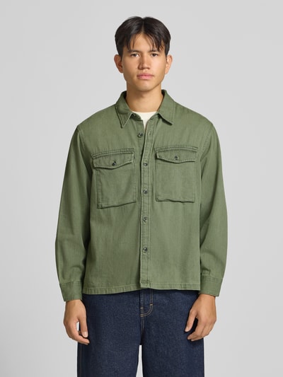 Männermodel trägt Loose Fit Jeanshemd aus reiner Baumwolle von Levi's® in Olivgrün mit zwei Brusttaschen, Ganzkörperansicht von vorne.