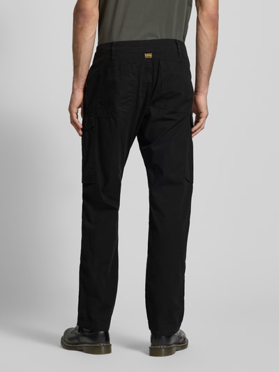 Männermodel trägt Straight Fit Cargohose mit Gesäßtaschen von G-Star Raw in Schwarz, Baumwolle, sichtbar sind Gesäß- und Eingrifftaschen, Ganzkörperansicht Rückansicht.