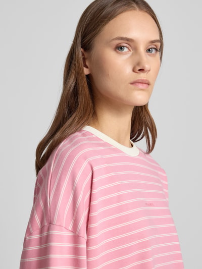 Vrouwenmodel draagt Regular Fit Longsleeve uit puur katoen van OH APRIL in roze met witte strepen, ronde hals, detailopname zijkant, ruglengte bij maat S 53 cm.