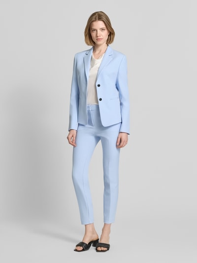 Frauenmodel trägt Slim Fit Hose mit Bügelfalten Modell 'HAGONIA-1' von HUGO, Optik: Unifarben, Passform: Slim-Fit, Logo-Applikation, Haken-Reißverschluss, seitliche Eingrifftaschen, hellblau, glatte Textur, Ganzkörperansicht von vorne.