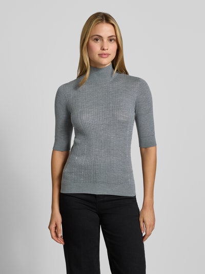Frauenmodel trägt Slim Fit Longsleeve aus reiner Lanawolle Modell 'Maglia Costine' von Liu Jo White, grau, semitransparent, Ganzkörperansicht von vorne.