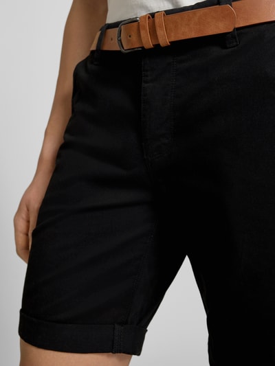 Männermodel trägt schwarze Shorts mit Gürtel Modell 'MIKE' von Redefined Rebel, Regular Fit, Nahaufnahme Oberkörper, Fokus auf Bund und Taschen.