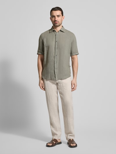 Männermodel trägt Leinenhose mit Schnürung und Gesäßtaschen von MCNEAL in Beige, aus Reinem Leinen, Regular-Fit, Ganzkörperansicht von vorne.