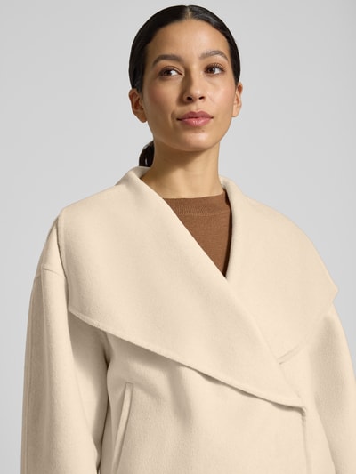 Frauenmodel trägt Jacke aus Woll-Mix Modell 'Naria' von Someday in Creme mit Relaxed-Fit und Druckknopfverschluss, Nahaufnahme Oberkörper.