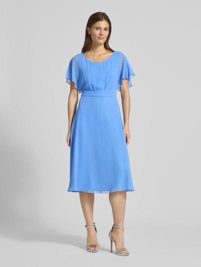 Kobiece modelka nosi Knielanges Kleid mit Rundhalsausschnitt od Vera Mont, półprzezroczysty materiał, krój taliowany, okrągły dekolt, wszyty zamek błyskawiczny, z krótkim rękawem, halka pod spódnicę, długość tyłu w rozmiarze 36: 102 cm, szerokość w rozmiarze 36: 37 cm, długość rękawa w rozmiarze 36: 27 cm, jasnoniebieski kolor, gładka faktura, widok całej sylwetki z przodu.