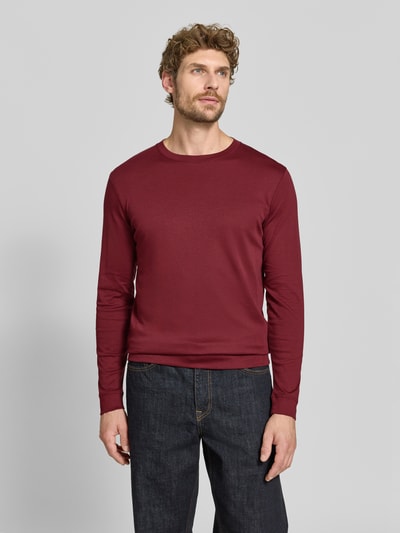Männermodel trägt Regular Fit Longsleeve aus reiner Baumwolle Modell 'Pima' von RAGMAN in Dunkelrot, glatte Textur, Ganzkörperansicht von vorne. Herren Longsleeve, Rundhalsausschnitt, Rückenlänge bei Größe M 69 cm.