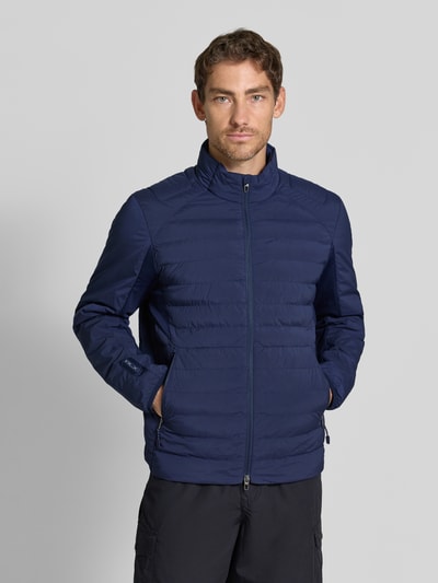 Męski model nosi Regular Fit Sweatjacke mit Steppung od Polo Ralph Lauren, granatowa, pikowana tekstura, widok całej sylwetki z przodu.