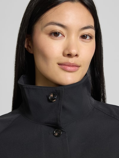 Frauenmodel trägt Jacke mit Knopfleiste von someday in Schwarz mit hohem Stehkragen und Raglanärmeln, Nahaufnahme Oberkörper. Lockere Passform, elastische Abschlüsse, Rückenlänge 42 cm, Brustweite 50 cm, Ärmellänge 50 cm.