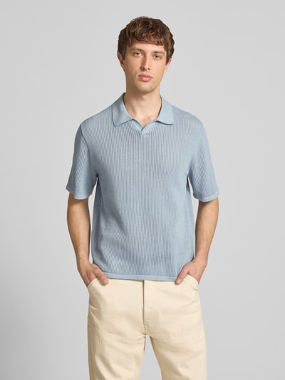 Männermodel trägt Regular Fit Strick-Poloshirt Modell 'CASSIS' von Jack & Jones, hellblau, reine Baumwolle, V-Ausschnitt, Ganzkörperansicht von vorne.