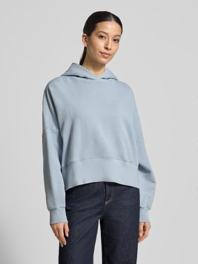 Frauenmodel trägt Relaxed Fit Hoodie aus reiner Baumwolle von Marc O'Polo, Optik: Unifarben, Passform: Relaxed-Fit, Label-Print, überschnittene Schultern, Kapuze, Langarm, Ärmelabschluss: Gerippt, Rumpfabschluss: Gerippt, Materialverarbeitung: Sweat, Ganzkörperansicht von vorne.