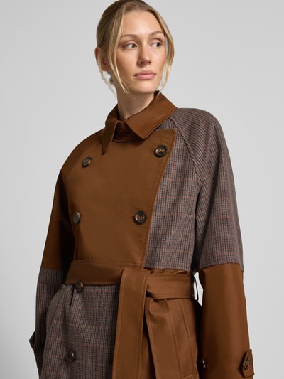 Modelka nosi płaszcz Loose Fit Mantel aus Woll-Mix Modell 'KAGU' od Essentiel Antwerp w kolorach brązu i kratki, zbliżenie na górną część ciała.