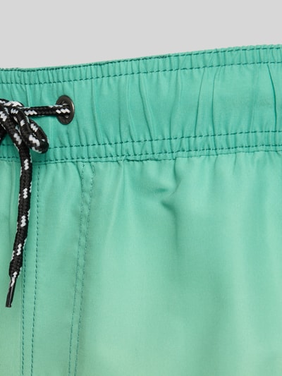 Produktfoto, Badeshorts mit Gesäßleistentasche Modell 'BHRISLEA GRADIENCE' von Blend, Loose-Fit, elastischer Bund mit Kordelzug, Label-Detail, seitliche Eingrifftaschen, glatte grüne Oberfläche, Detailaufnahme.