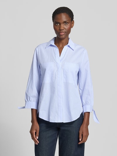 Vrouwenmodel draagt Regular Fit Bluse mit 3/4-Arm van Christian Berg Woman van puur katoen met all-over look, overhemdkraag, V-hals, borstzakken, 3/4-mouw, ruglengte bij maat 36: 72 cm, mouwlengte bij maat 36: 50 cm, kleuren lichtblauw gestreept, materiaal met fijne textuur, vooraanzicht bovenlichaam.