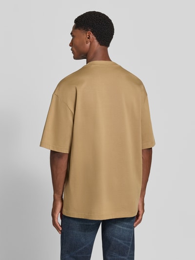 Männermodel trägt Regular Fit T-Shirt aus reiner Baumwolle Modell 'Dinkee' von HUGO in lichtbruin op effen achtergrond, Ganzkörperansicht Rückansicht, Heren T-Shirt von HUGO.