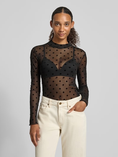 Vrouwenmodel draagt zwart slim fit shirt met lange mouwen met all-over motief van model 'JESHI' van PIECES, voorkant borst close-up.