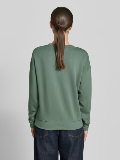 Frauenmodel trägt Sweatshirt mit Rundhalsausschnitt Modell 'Ima' von MSCH Copenhagen in Grün, Viskose-Mix mit Stretch-Anteil, Regular-Fit, überschnittene Schultern, elastische Abschlüsse, glatte Oberfläche, Ganzkörperansicht Rückansicht.