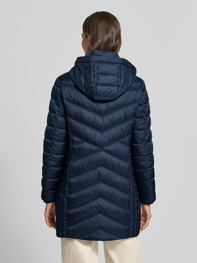 Männermodel trägt Steppmantel mit Zweiwege-Reißverschluss von Christian Berg Woman Selection in Dunkelblau, krój slim fit, kapuze z tunelowym ściągaczem, kieszenie na suwak, długość pleców w rozmiarze 36: 83 cm, szerokość ramion w rozmiarze 36: 40 cm, szerokość klatki piersiowej w rozmiarze 36: 48 cm, długość rękawa w rozmiarze 36: 65 cm, widok całej sylwetki z tyłu
