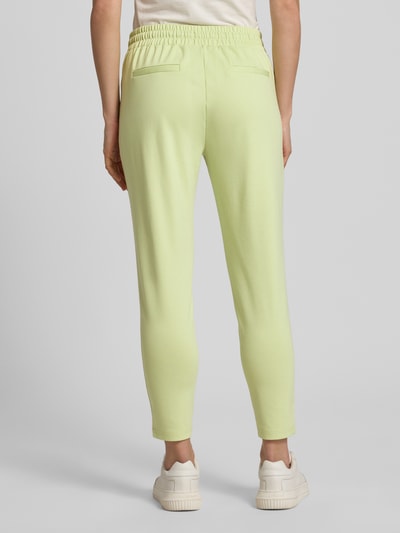 Frauenmodel trägt Sweatpants mit Tunnelzug Modell 'KATE' von ICHI in zartem Gelb, Material-Mix mit Viskose-Anteil, Regular-Fit, elastischer Bund, Ganzkörperansicht Rückansicht.