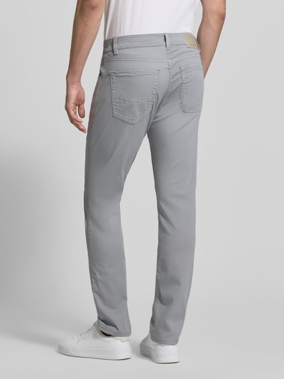 Mężczyzna nosi jeansy z mieszanki bawełny z dodatkiem streczu Pierre Cardin Jeans mit Label-Detail Modell 'Lyon', krój regular fit, szare, wpuszczane kieszenie, detal z logo, szerokość w rozmiarze 32/32: 41 cm, długość wewnętrzna nogawki: 80 cm, pełny widok sylwetki z tyłu.