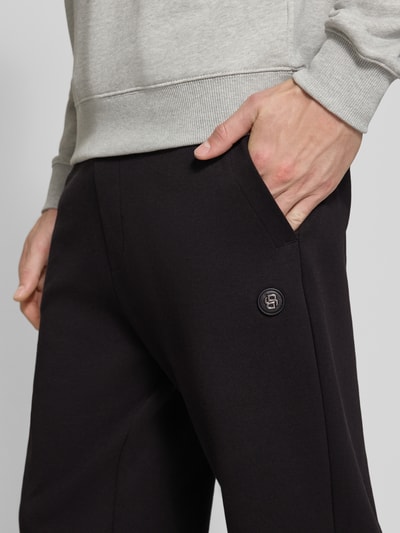 Männermodel trägt schwarze Regular Fit Sweathose aus Baumwoll-Mix Modell 'C-Locsin 01' von BOSS, Nahaufnahme Oberkörper, Herren Sweathose von BOSS