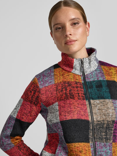 Frauenmodel trägt Jacke mit Stehkragen und Reißverschluss von Apricot, bunt gemusterte Farbflächen, gerader Schnitt, Nahaufnahme Oberkörper, Rückenlänge 60 cm, Schulterbreite 38 cm, Brustweite 49 cm, Ärmellänge 63 cm.