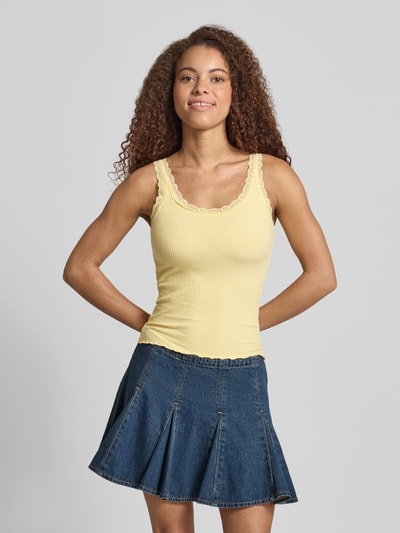 Frauenmodel trägt Slim Fit Tank Top aus Bio-Baumwoll-Mix Modell 'SARA' von Only in Uni-Gelb mit Spitze und schmalen Trägern, Feinripp, Ganzkörperansicht von vorne.