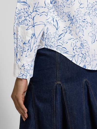 Frauenmodel trägt Regular Fit Bluse im Allover-Look von Gant, weiß mit blauem Blumenmuster, reine Baumwolle, Nahaufnahme Oberkörper.