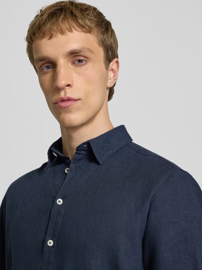 Männermodel trägt Slim Fit Leinenhemd mit Viskose-Anteil Modell 'Bobby' von Blend in Dunkelblau mit Kentkragen, Nahaufnahme Oberkörper, Leinen-Mix, durchgehende Knopfleiste, Kurzärmelig, Rückenlänge 75 cm, Schulterbreite 38 cm, Ärmellänge 23 cm, Größe M.