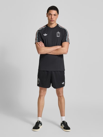 Männermodel trägt Regular Fit Sweatpants mit Label-Detail Modell 'Belgien 26' von adidas Originals, Optik: Unifarben, Materialverarbeitung: Sweat, Ganzkörperansicht von vorne.