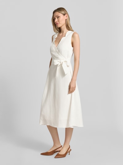 Frauenmodel trägt Midikleid aus Leinen-Viskose-Mix in Wickel-Optik von Christian Berg Woman Selection, cremefarben, A-Linie, V-Ausschnitt, Ganzkörperansicht von vorne. Rückenlänge bei Größe 36: 120 cm, Brustweite 45 cm.