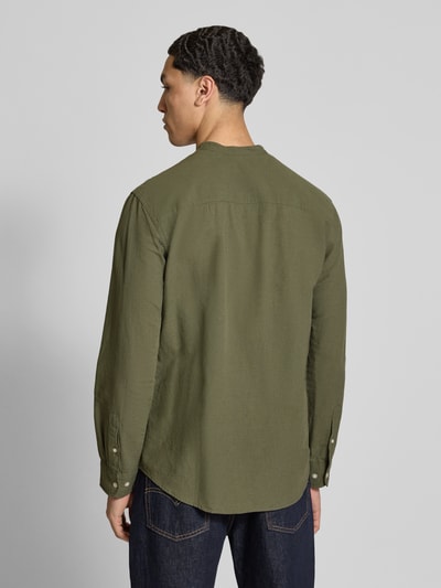 Męski model nosi koszulę casualową z mieszanki bawełny i lnu model 'BREEZE' od Jack & Jones, krój regular fit, stójka, listwa guzikowa, długość tyłu w rozmiarze M: 75 cm, szerokość ramion w rozmiarze M: 48 cm, długość rękawów w rozmiarze M: 64 cm, kolor oliwkowy, gładka faktura, widok całej sylwetki z tyłu.