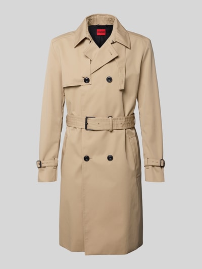 Produktfoto, Regular Fit Trenchcoat met gun flap Model 'MALUKS2511' van HUGO in effen beige, dubbele knoopsluiting, platte kraag, tailleriem met gesp, waterafstotend, loopsplit, achterpas, lange mouwen met mouwboord, zij-steekzakken en binnenzak, labelstitching.