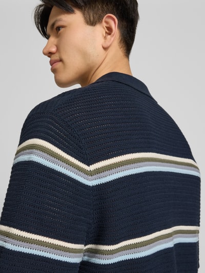 Männermodel trägt Regular Fit Poloshirt mit Streifenmuster Modell 'MAINE' von Jack & Jones aus reiner Baumwolle in Dunkelblau, Nahaufnahme Rückenansicht.