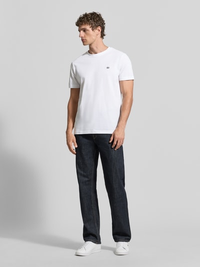 Männermodel trägt T-Shirt aus Baumwolle mit Rundhalsausschnitt von Christian Berg Men in Weiß, Regular-Fit, Label-Detail, Ganzkörperansicht von vorne.