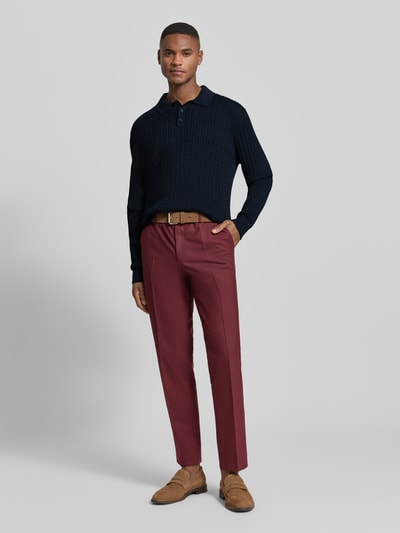 Mannenmodel draagt 'Strickpullover mit Polokragen' van MCNEAL in donkerblauw, pure katoen, regular fit, geribde boorden, voorkant volledige lichaamsaanzicht.