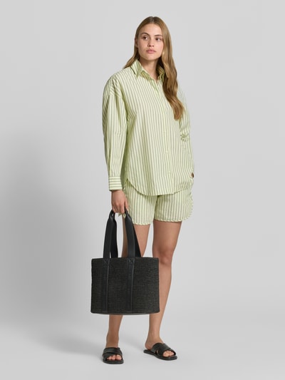 Modelka nosi Oversized Hemdbluse aus reiner Baumwolle Modell 'BOSTATTA' od BOSS Orange, paski, bawełna, luźny krój, widok całej sylwetki z przodu.