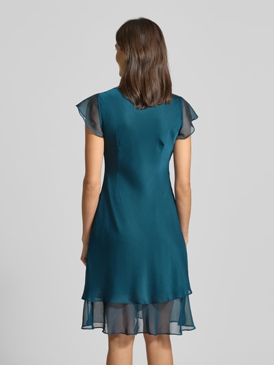 Kobiece modelka nosi knielanges Cocktailkleid mit Wasserfall-Ausschnitt od Christian Berg Cocktail, szyfon, linia A, długość do kolan, widok całej sylwetki od tyłu.