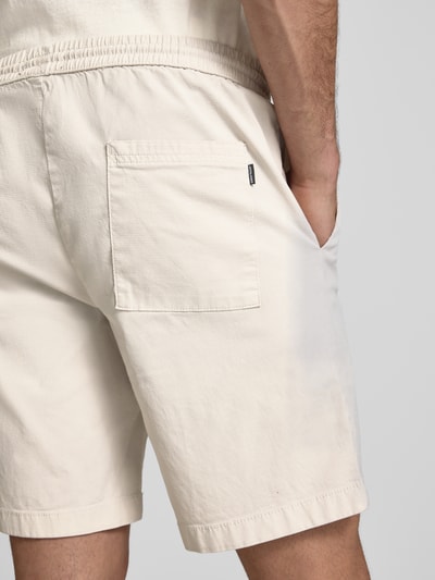 Männermodel trägt Shorts mit elastischem Bund Modell 'JAIDEN CARTER' von Jack & Jones, cremefarben, Strukturmuster, Rückenansicht, Nahaufnahme Oberkörper, Material aus Baumwoll-Elasthan-Mix, Regular-Fit, Bundweite 43 cm, Innenbeinlänge 20 cm.