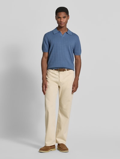 Mężczyzna nosi Regular Fit Poloshirt mit Strukturmuster von Christian Berg Men z bawełny w kolorze niebieskim, krótki rękaw, kołnierzyk polo, dekolt w serek, fakturowany wzór, długość tyłu w rozmiarze M: 69 cm, długość rękawów w rozmiarze M: 27 cm, Ganzkörperansicht von vorne.