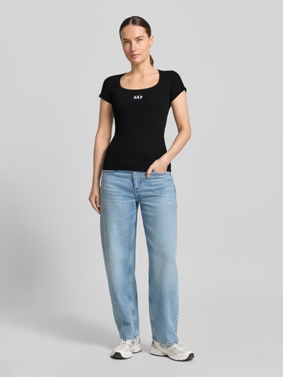 Frauenmodel trägt T-Shirt mit Logo-Stitching von GAP aus schwarzem Baumwoll-Mix mit Stretch-Anteil, körpernahe Passform, Ganzkörperansicht von vorne.