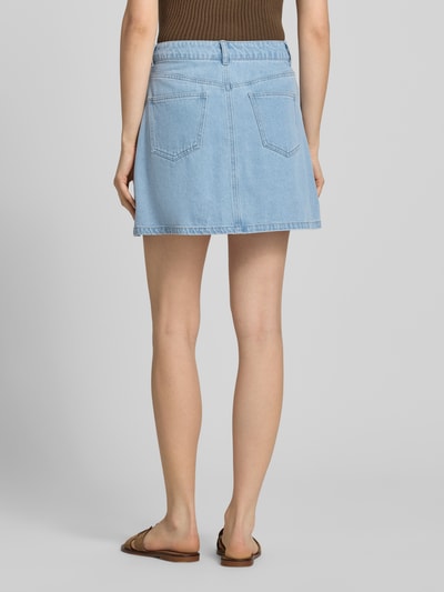 Vrouwenmodel draagt A-lijn dames jeansrok van Pieces, model 'ABBI' in denimlook, mix van katoen en viscose, minilengte, twill, 5-pocketmodel, lichtblauw. Ganzkörperansicht Rückansicht.