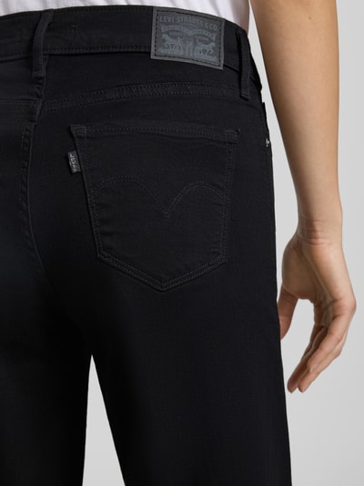 Vrouwenmodel draagt Jeans met 5-Pocket-Design van Levi's®, zwarte katoenmengsel met stretch, losse pasvorm, detailopname achterkant.