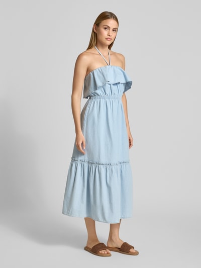 Frauenmodel trägt Jeanskleid mit Neckholder Modell 'LUMIRA' von Drykorn aus Reine Baumwolle, Taillierter Schnitt, Midikleid, Volant am Ausschnitt, helle blaue Denim-Optik, glatte Textur, Rückenlänge 110 cm, Brustweite 33 cm, Ganzkörperansicht von vorne.