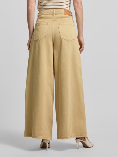 Frauenmodel trägt Wide Leg Jeans im 5-Pocket-Design von Stefanel, ausgestellter Schnitt, reine Baumwolle, helle Beige-Töne, Ganzkörperansicht Rückansicht.