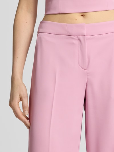 Vrouwenmodel draagt Hose mit weitem Bein und Paspeltaschen am Gesäß van Jake*s Cocktail, roze, wijde pijp, materiaal-mix met stretch, persvouwen, detailopname heupen.