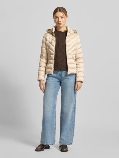 Frauenmodel trägt taillierte Steppjacke mit Zweiwege-Reißverschluss Modell 'ANYA' von Beaumont Amsterdam in Beige, Ganzkörperansicht von vorne. Kontext: Damen Steppjacke mit Kapuze, Tunnelzug, Rückenlänge 55 cm, Schulterbreite 38 cm, Brustweite 48 cm, Ärmellänge 61 cm.