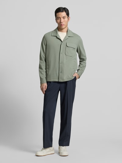 Męski model nosi Hemdjacke mit Reverskragen od Antony Morato, kolor oliwkowy, bawełniany materiał, luźny krój, widok całej sylwetki z przodu.